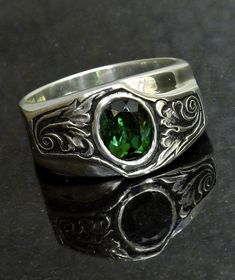 Silver Engraved Ring Green Tourmaline Sterling Silver  Statement Ring  This custom silver band ring was made to be the center of attention. Cast in sterling silver with a 8x6.5mm oval green tourmaline set in the center.   On either side of the vibrant green tourmaline is hand engraved sculpted leaf scroll work. Sculpting ans antiquing the background brings real life to the design.  The ring is a size 9.5, and ready to ship. At 12mm wide across the top, the band tapers to 4.8mm at the bottom for Engraved Silver Ring, Silver Dimes, Engraved Ring, Scroll Work, Pattern Ring, Statement Ring Silver, Silver Engraving, Silver Band Ring, Men's Ring