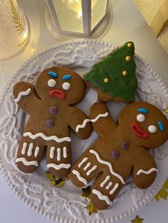 three decorated gingerbreads on a white plate