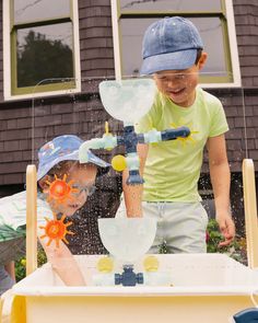 two children playing in a water play table