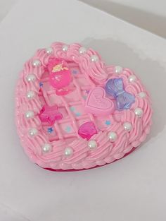 a pink heart shaped cake sitting on top of a table