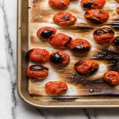 a pan filled with cooked tomatoes on top of a table