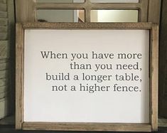 a wooden frame with a quote on it sitting in front of a brick wall next to a mirror