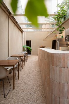 an indoor dining area with tables and chairs next to a wall that has plants growing on it