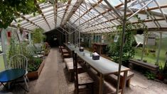 the inside of a greenhouse with tables and chairs