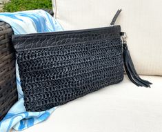 Hand crocheted raffia is teamed with a black veg tanned leather to create a lovely summer clutch. The raffia comes from a sustainable source and the leather and suede is redundant stock from a top end brand. As leather is from redundant stock the texture of leather might differ slightly from photo. Fully lined with zipped closure and finished with a detachable suede tassel. Other cols of suede tassels can also be bought to accessorise your bag. Dimensions: 170mm deep x 275mm wide Sorry but due t Chic Black Woven Clutch, Summer Black Rectangular Clutch, Black Clutch For Summer Evenings, Black Clutch For Summer Evening Events, Black Clutch For Evening And Summer, Chic Black Summer Clutch, Black Evening Clutch For Summer, Black Handwoven Clutch For Everyday Use, Black Woven Pouch Clutch