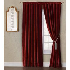 a red curtain hanging on the side of a wall next to a window with a mirror