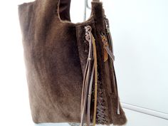 "BROWN FUR TOTE Woven Leather Tassels Calf Hair Bag with Hand Leather Cross Weave Country South Western Cowgirl Fur Bag Shoulder bag. A personal favorite; beautifully soft to the touch. Wears easily over shoulder, stylish and luxurious. We carefully hand pick all cow hides ourselves; pre planning each piece and the best markings, so that every piece is unique & no two are ever alike. Using the best quality cow leathers for the backing. With age, cow leather gets that vintage softness and fee Artisan Brown Bags With Fringe, Brown Fringe Tote Shoulder Bag, Brown Fringe Pouch Shoulder Bag, Artisan Brown Fringe Bag, Hair Bag, Western-themed Brown Leather Shoulder Bag, Cowhide Bag, Matching Keychains, Fan Style