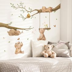 there are many stuffed animals hanging on the tree branch wall decals in this bedroom