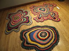 three colorful rugs on the floor in a room