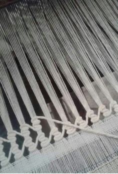 a close up view of a weaving machine with white yarn on the bottom and sides