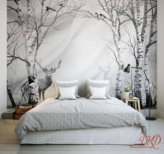 a bed sitting under a large wall mural in a bedroom