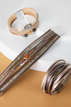 Introducing our Glimmer Leather Bracelet, crafted for glamorous nights out. It showcases metallic leather strands adorned with intricately beaded gemstones in rich shades of dark brown. Perfect for adding a touch of sparkle to any evening ensemble, it's a statement piece that combines versatility with timeless allure. Elevate your accessory collection with the allure of our Glimmer Leather Bracelet.

Materials: Leather, Glass Beads
Size: 7.5" x 2"
Magnetic Clasp
Imported Work Wardrobe Essentials, Leather Cord Bracelets, Velvet Kimono, Best Leather, Summer Kimono, Handcrafted Bracelets, Leather Bracelets, Lightweight Scarf, Bracelets For Women