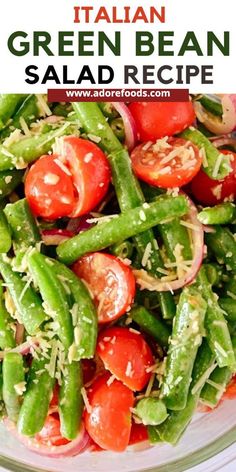 green bean salad with tomatoes and onions in a glass bowl on top of a white table