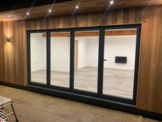 an empty room with sliding glass doors and wood paneling