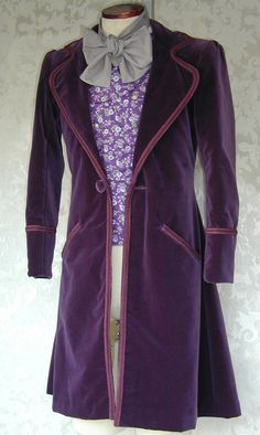 a mannequin wearing a purple coat with a bow tie on it's neck