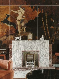 a fireplace in a living room with paintings on the wall