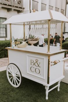 a white and gold cart with wine glasses on it