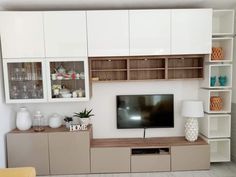 a flat screen tv sitting on top of a wooden entertainment center in a living room