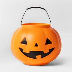 an orange halloween pumpkin bucket with black eyes