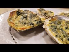 three oysters with spinach and cheese on a plate