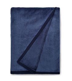 a blue towel folded on top of a white surface with a black stripe down the middle