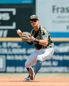 a baseball player kneeling on the field with his glove in one hand and mitt in the other