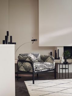 a black and white couch sitting in a living room next to a table with vases on it