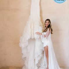 a woman standing next to a wedding dress