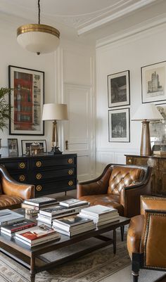 a living room with leather furniture and pictures on the wall above it's coffee table