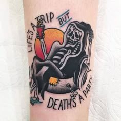 a tattoo on the leg of a person with a knife and skull sitting in a chair