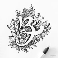 the letter e is surrounded by flowers and leaves on a sheet of paper with a marker