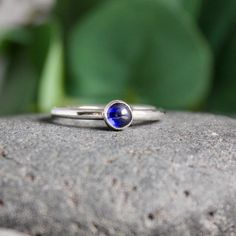 Do you need a gift for someone with a September birthday or to celebrate your 5th wedding anniversary? This sterling silver synthetic sapphire stacking ring is perfect if your birthstone is sapphire or you need a simple navy blue ring. Here are the details:This ring is made with either a rose cut (faceted) or smooth 5mm synthetic sapphire cabochon set in a sterling silver bezel and on a sturdy band handmade in your size. It can be worn with other stackable rings, or by itself.Please select your Minimalist Sapphire Ring With Bezel Setting As Gift, Minimalist Sapphire Birthstone Ring As Gift, Minimalist Blue Sapphire Ring For Anniversary, Adjustable Bezel Set Sapphire Ring Gift, Blue May Birthstone Rings, Gift Sapphire Ring With Bezel Setting, Gift Sapphire Ring With Bezel Setting And Round Band, Sapphire Stackable Gemstone Rings As Gift, Gift Sapphire Solitaire Ring