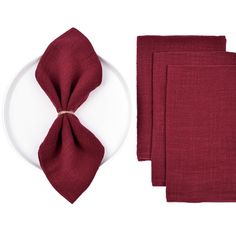 red napkins and place setting on white plate with wine colored linen, isolated against white background