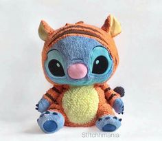 an orange and blue stuffed animal with big eyes