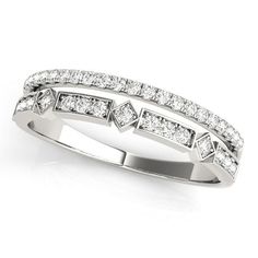 a white gold ring with diamonds on the sides and an arrow pattern in the middle