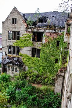 an old building with ivy growing on it's side and windows in the middle