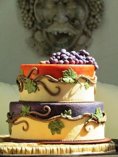 a multi layer cake with grapes on top