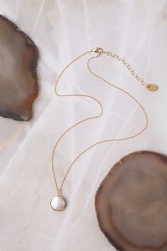 Always a favorite, this simple necklace features a pearl coin. Set in gold and dangling from a gold filled chain, this handcrafted piece is a timeless addition to any jewelry collection. A gold filled lobster claw clasp allows the length to be adjusted by 2". Gold Filled (Lead & Nickel Free) Pearl 16.5-18.5" adjustable length, with gold filled lobster claw clasp We hand select our natural materials, thus there may be slight variations in color and/or size that will not detract from the overall a Elegant 14k Gold-filled Coin Necklace, Gold Pearl Jewelry With Coin Pendant, Elegant Medallion Necklace With Lobster Clasp, Elegant Pearl Necklace With Coin Pendant, Pearl Chain Coin Necklace, Gold Pearl Charm Necklaces With Round Pendant, Pearl Chain Coin Necklace Gift, Pearl Necklace With Coin Pendant As Gift, Gold Pearl Round Pendant Charm Necklaces