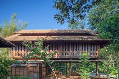 an old wooden house with a hammock on the porch