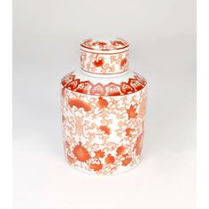 an orange and white vase sitting on top of a table