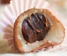 a piece of food sitting on top of a pink paper cupcake wrapper,