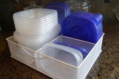 plastic dishes are stacked in a container on the counter