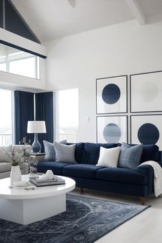 a living room with blue couches and white coffee table in front of large windows