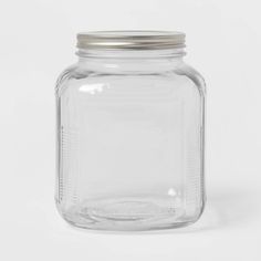 a clear glass jar with a metal lid on a white background, it is empty and ready to be used for storage