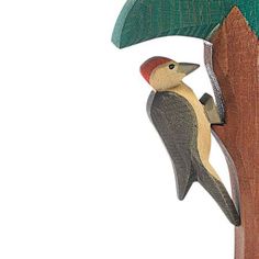 a bird perched on top of a tree next to a wooden pole with two trees