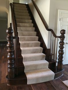 the stairs are made of wood and have white carpet