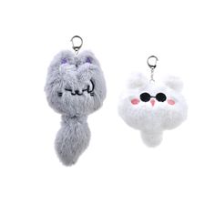 two furry key chains with eyes and ears on them, one is grey and the other is white