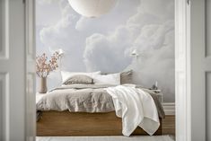 a bedroom with clouds painted on the wall