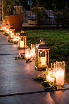 many lit candles are lined up on the ground