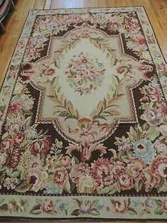 a large rug with flowers on it in the middle of a wooden flooring area